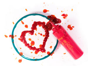 ketchup squeeze bottle that has drawn a messy heart of a plate